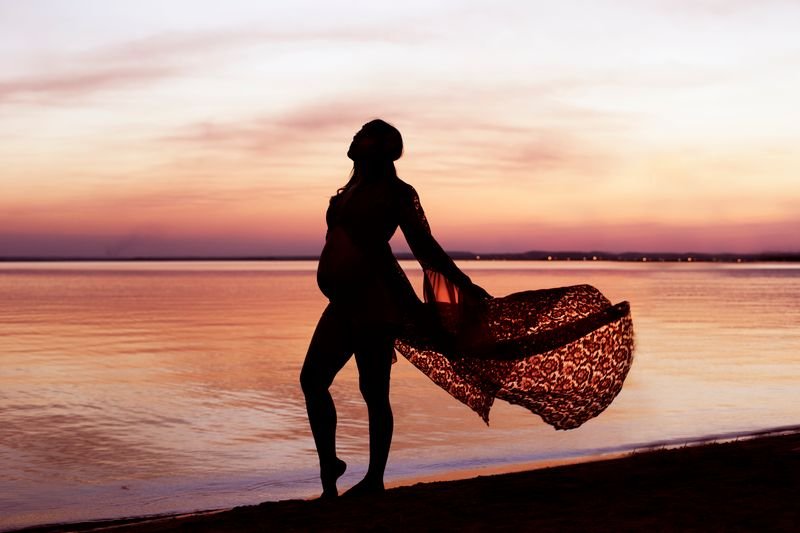 Pregnant woman silhouette at sunset symbolizing new beginnings