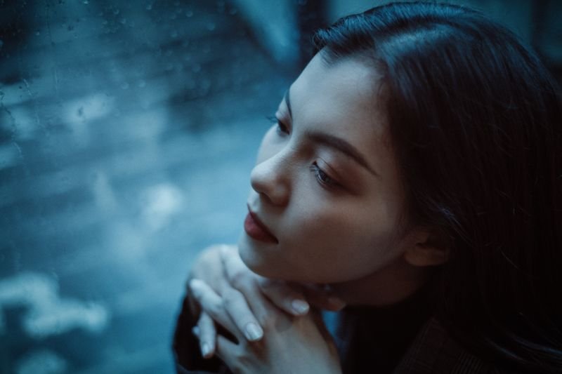 Lonely person gazing out a rainy window