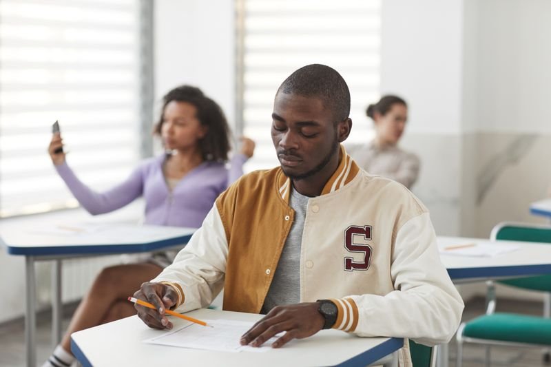 Stressed student sitting an exam in a classroom